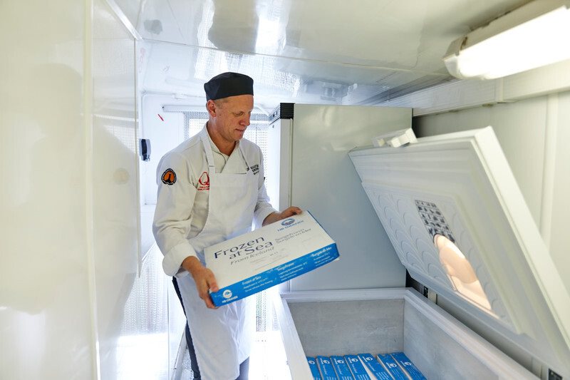 Employee holding a box of frozen fish fillets