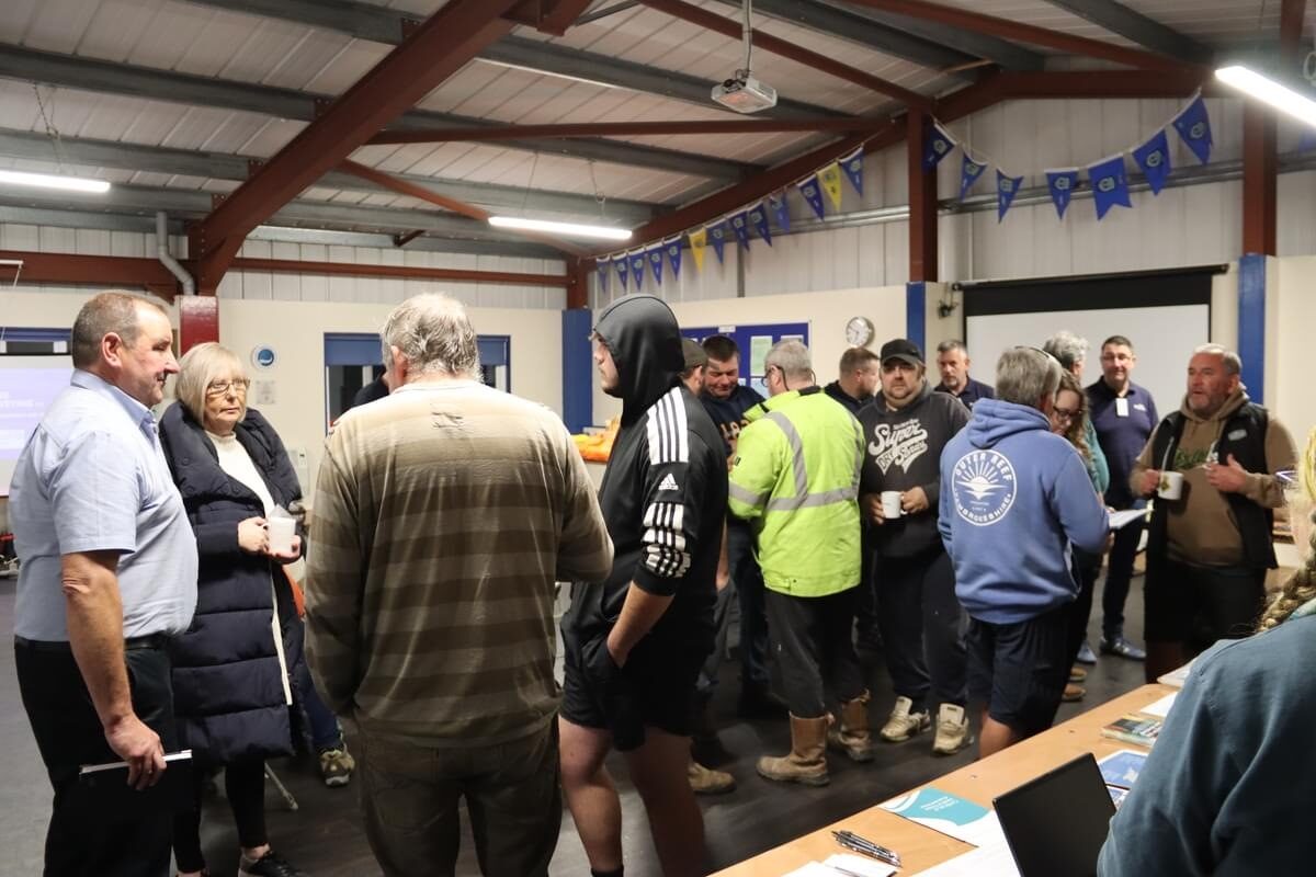 People standing in groups inside a hall during an event